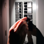 A homeowner looking at their electrical panel from Firefly Electrical