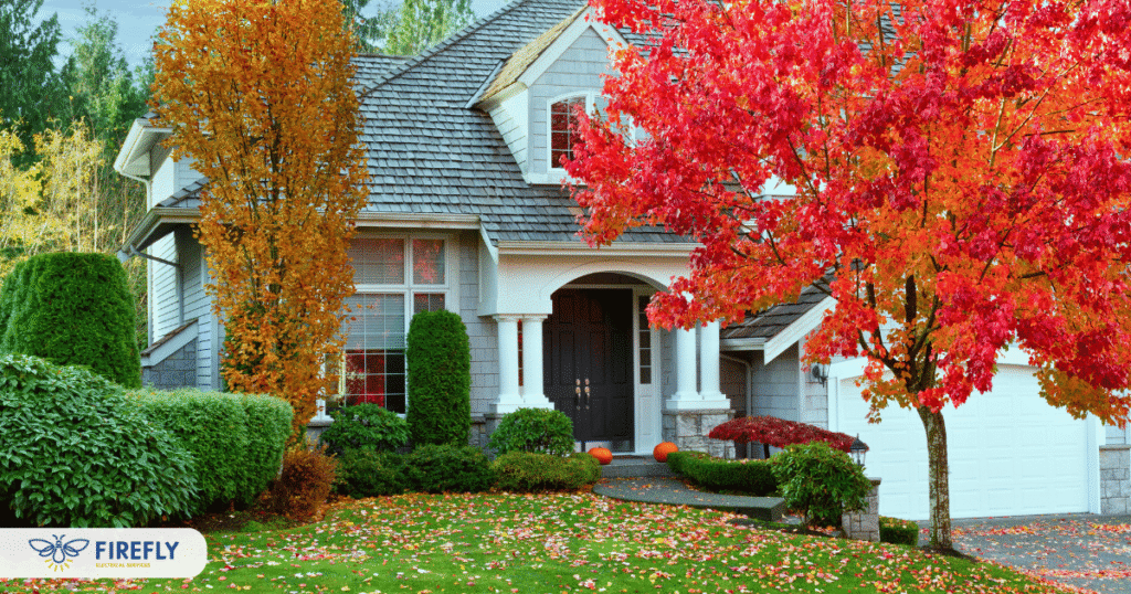 Residential home surrounded by colorful fall foliage with Firefly Electrical Services branding.