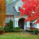 Residential home surrounded by colorful fall foliage with Firefly Electrical Services branding.